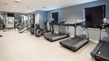 A gym with treadmills, elliptical machines, and a weight machine.