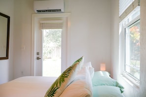 Ein Schlafzimmer mit einem Bett, einem Fenster und einer Klimaanlage.
