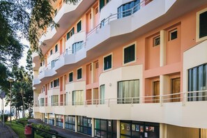 A multi-story hotel with balconies, large windows, and a ground-level retail space. - Cozy Duplex Retreat by Green Parc & Ocean View (Funchal)