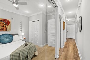 A bedroom with a bed, a nightstand, a lamp, a painting, and a ceiling fan. - Sleek City Nest 1BD | Walk to N Liberties | Fits 2 (Philadelphia)