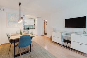 A modern living space with a dining area, kitchen, and entertainment unit. - New Listing (Engelberg)