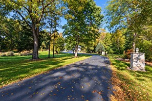 A paved pathway in a park-like setting with trees and a stone structure. - GateHouse Estate with Hot Tub/Theater/Game Room (Twin Lakes)