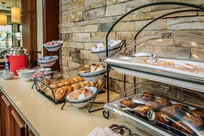 A buffet setup with various food items and a coffee station.