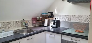 Eine Küche mit Spüle, Kaffeemaschine und einem Korb.