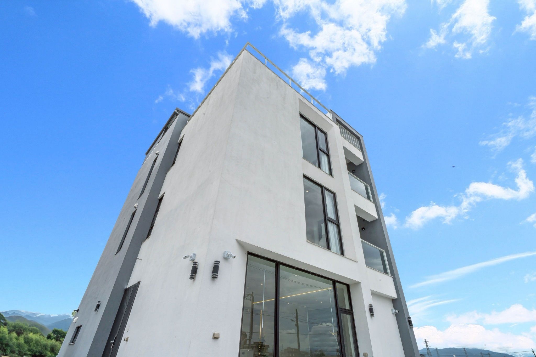 Un edificio moderno con techo plano, ventanas amplias y cielo despejado.