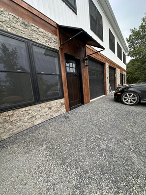 Un bâtiment moderne avec une façade en pierre, de grandes fenêtres et un garage.
