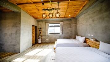A bedroom with two beds, a wooden ceiling, a window with curtains, and a shelf with items.