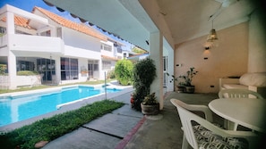 A poolside area with a view of a building with a tiled roof, potted plants, and outdoor furniture. - Spacious Ocean view 4 bedroom house with pool close to Bacocho beach (Puerto Escondido)