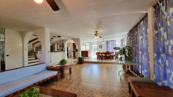 A spacious living area with a staircase, dining area, and a ceiling fan. - Spacious Ocean view 4 bedroom house with pool close to Bacocho beach (Puerto Escondido)