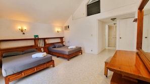 A room with two beds, a wooden table, and a mirror. - Spacious Ocean view 4 bedroom house with pool close to Bacocho beach (Puerto Escondido)