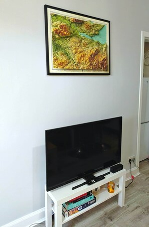 Una televisió de pantalla plana sobre un suport blanc, amb un mapa emmarcat a dalt.
