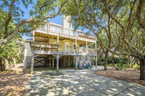 A two-story wooden house with a balcony, surrounded by trees. - Secluded Duck Home, Steps to Beach, Community Pool (Duck)