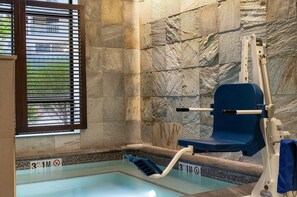 A pool area with a blue floating chair, a lifeguard stand, and a window with blinds. - 3 Bedroom Presidential In Avon, Co (Avon)