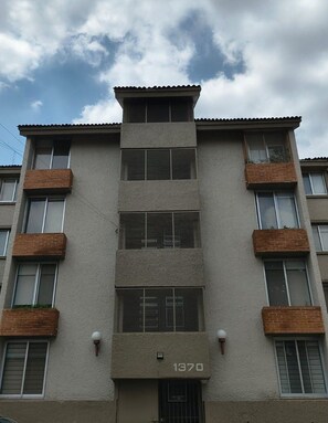 A multi-story building with a flat facade, numbered 1370, featuring balconies and a uniform window pattern. - Dptos. Las Rosas Expo Guadalajara (Guadalajara)