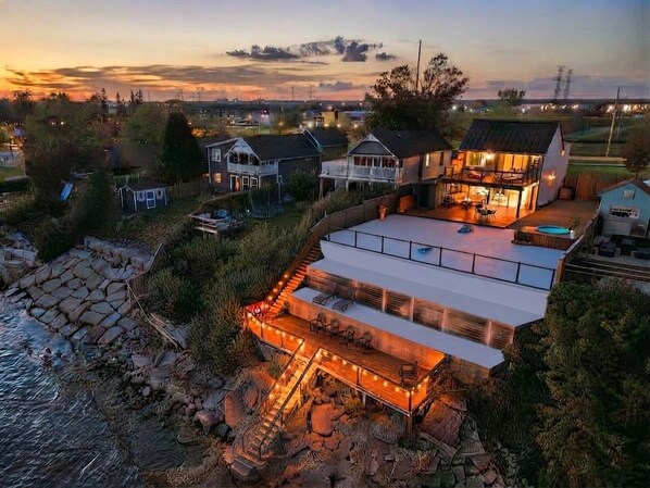 A residential property with a large deck, a swimming pool, and a view of the surrounding area.