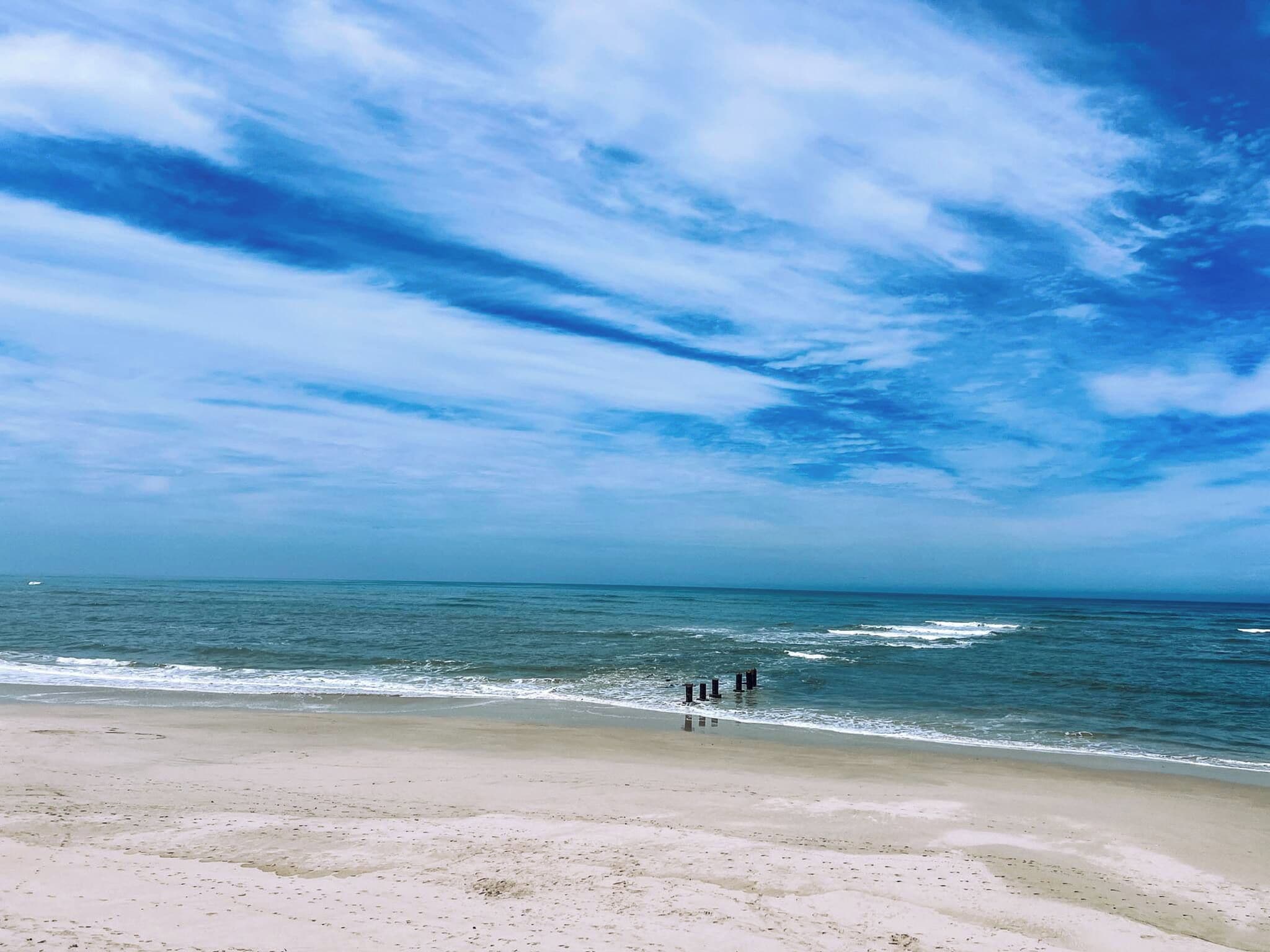 A beach with a clear sky and calm sea.