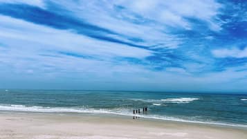 Una playa con cielo despejado y mar tranquilo.