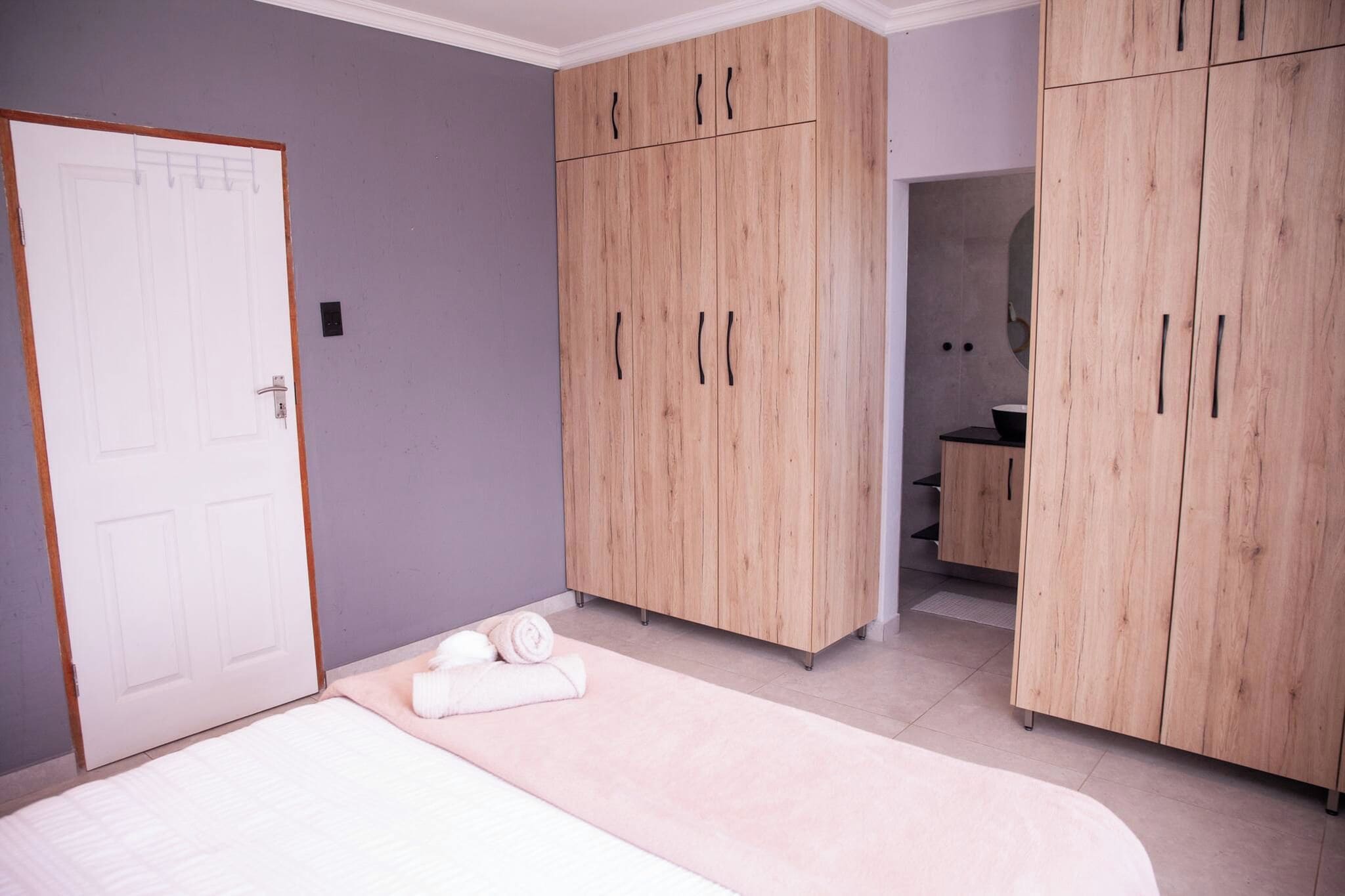 Un dormitorio con cama, armario y baño.