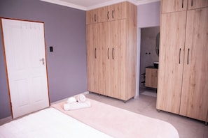 A bedroom with a bed, a wardrobe, and a bathroom. - Langa Elihle on Paradise Beach (Paradise Beach)