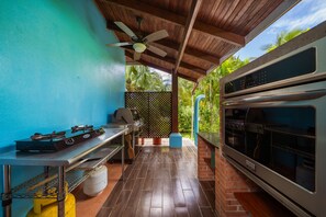 A covered outdoor kitchen area with a gas stove, grill, and oven. - Pool ~ BBQ ~ Walk to Beach ~ Golf Cart Parking ~ 3 TVs - Villaggio 324 (Potrero)