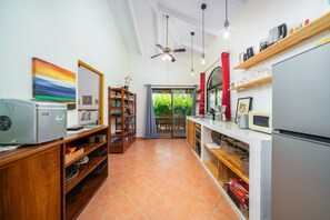 A compact kitchen with a refrigerator, microwave, and wooden shelves. - Pool ~ BBQ ~ Walk to Beach ~ Golf Cart Parking ~ 3 TVs - Villaggio 324 (Potrero)