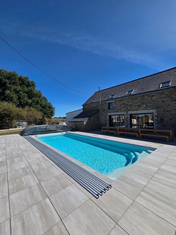 Une piscine avec un bâtiment en pierre en arrière-plan.