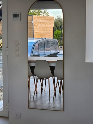 A modern interior with a dining area, a wooden wall, and a view of a blue car outside. - Holiday Home 'Le Boizeul' with Private Pool, Terrace and Air Conditioning (Nivillac)