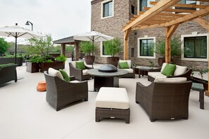 An outdoor patio area with wicker furniture, a round table, and potted plants. - 2 Double Studio w/ Kitchen & Free Daily Breakfast (San Antonio)