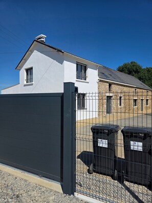 A gated property with a white building and a stone structure. - Group Cottages Les Boizeul Pool - 2x15 Guests with Private Pool, Air Conditioning and Wi-Fi (Nivillac)