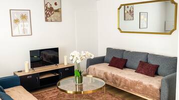 Un salon moderne avec un canapé, une table basse et un téléviseur.