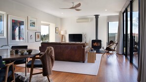 A modern living room with a fireplace, a television, and artwork on the walls. - Volante architectural Clunes getaway (Clunes)