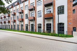 Ein modernes, mehrstöckiges Gebäude mit Ziegelverkleidung, großen Fenstern und einem Flachdach.
