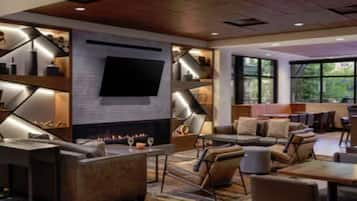 A modern interior with a fireplace, seating area, and large windows.