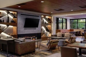 A modern interior with a fireplace, seating area, and large windows. - The Westin Riverfront Mountain Villages (Avon)