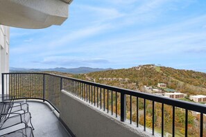 A balcony with a view of a hillside with buildings. - 2BR High Floor Suite | Pool/Sauna | Mountain Views (Sugar Mountain)