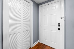 A closed white door with a keyhole and a handle, adjacent to a white closet with horizontal blinds. - 2BR High Floor Suite | Pool/Sauna | Mountain Views (Sugar Mountain)