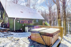 A rustic cabin with a hot tub and a sign that reads 'BAIT & TACKLE.' - Hillside Haven- a cozy Getaway in the heart of Hocking Hills (Rockbridge- Hocking Hills (Hillside Haven))