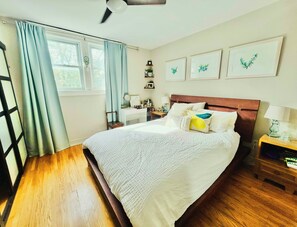 A bedroom with a bed, bedside tables, a desk, and a window with curtains. - Sweet Beach House in the City! Great neighbourhood; family and pet friendly (Toronto)