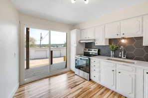A modern kitchen with white cabinetry, a stainless steel oven, and a hexagonal backsplash. - Prime Location! HGTV Design!20#4 (Omaha)