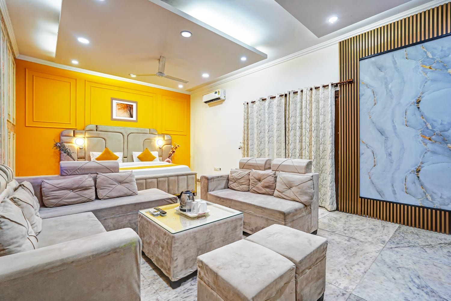 A modern living room with a sofa set, a coffee table, and a large painting on the wall.