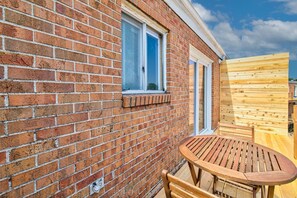 A brick building with a wooden deck and a table and chairs. - Prime Location! HGTV Design! (Omaha)