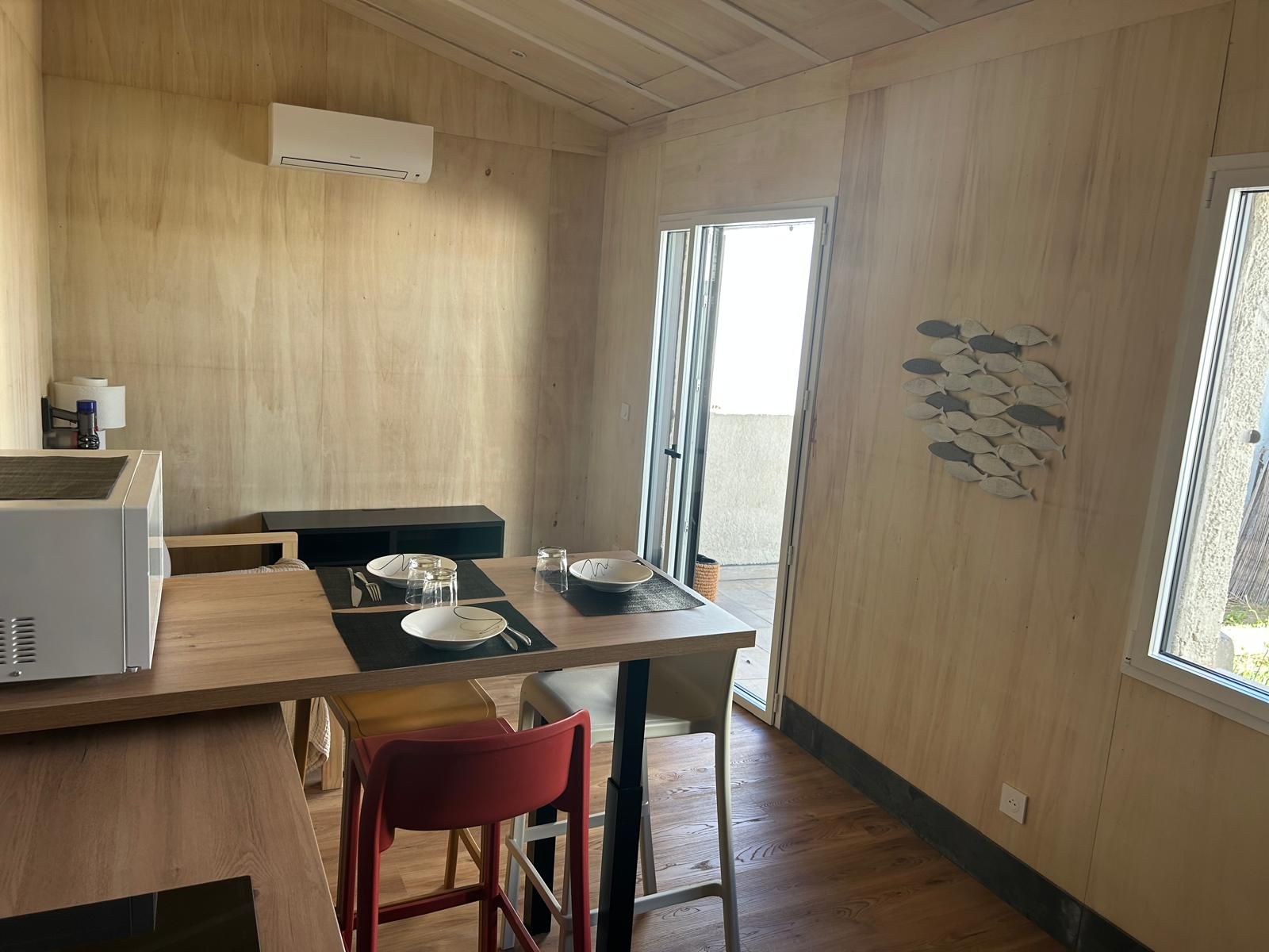 A compact kitchen with a dining area, a microwave, and a window with a view.