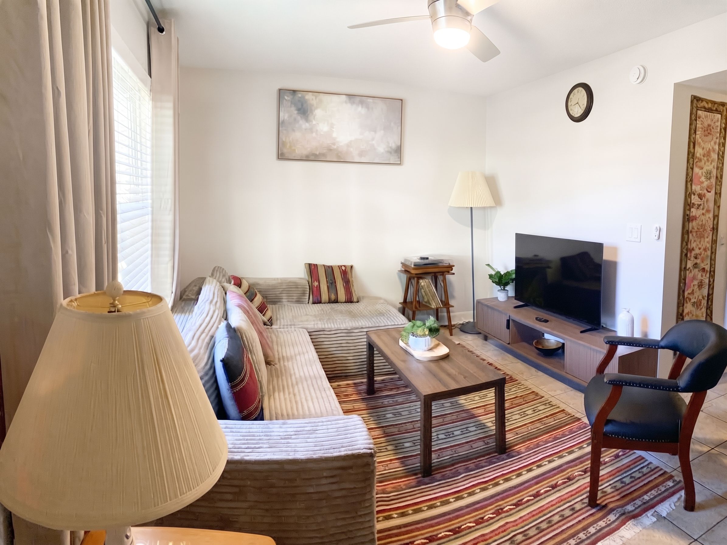 A living room with a sofa set, a coffee table, a TV, and a chair.
