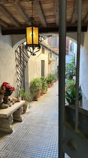 An indoor corridor with tiled flooring, potted plants, and a hanging lantern. - New Listing (Orvieto)