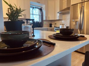 Un comptoir de cuisine avec une plante, un verre et un bol disposés sur un plateau.