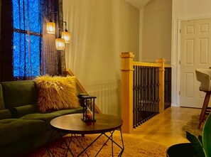 A cozy living room with a green sofa, a round coffee table, and a decorative hourglass.