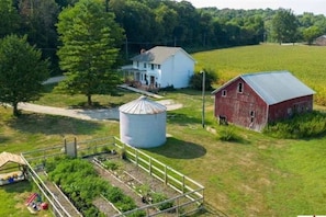 A rural property with a large white silo, a red barn, and a house with a porch. - Viral Farmhouse Sensation! 5 million+ views on FB! (Fort Calhoun)