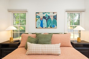 A bedroom with a bed, two nightstands, a painting, and windows. - The Wilmore Cottage by South End | King Bed, Skylights, Fireplace & Private Patios (Charlotte)