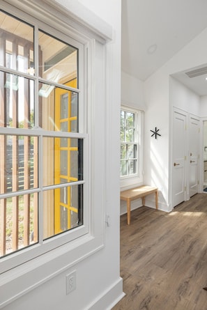Una habitación con un ventanal grande, un banco y una puerta decorada con una estrella.