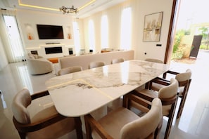 A modern dining area with a marble table and upholstered chairs. - New Listing (Marrakech)